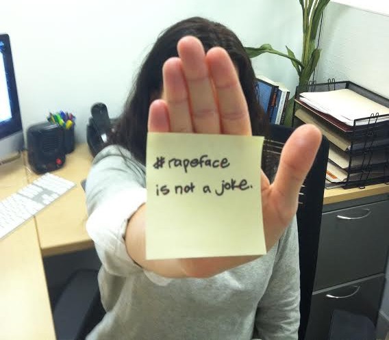 Survivor holding up a post-it note saying "hashtag rape face is not a joke"