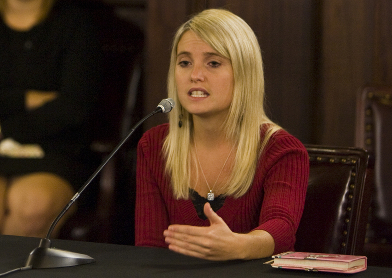 Portrait of child sexual abuse survivor Erin Merryn of "Erin's Law" speaking into a microphone.
