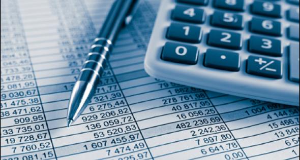 Congress Budget. A calculator and pen sitting on top of a chart with numbers