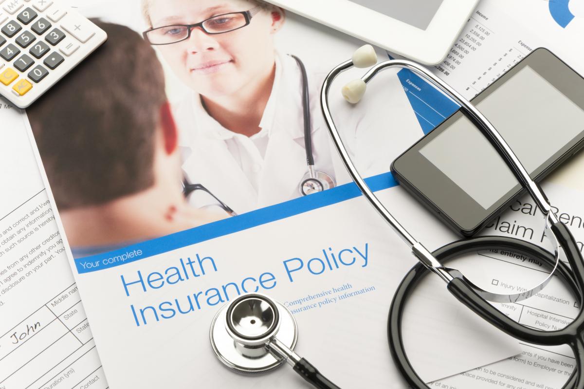 Health insurance plan brochures underneath stethoscope 