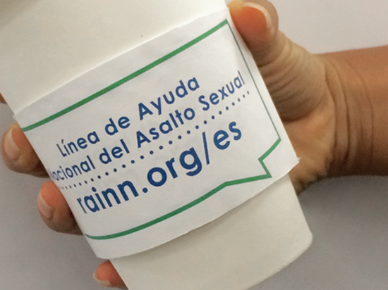 Spanish language coffee sleeves list the National Sexual Assault Hotline number